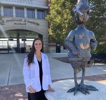 她泰勒 standing outside Morrison Stadium on Creighton campus next to Billy Bluejay statue.